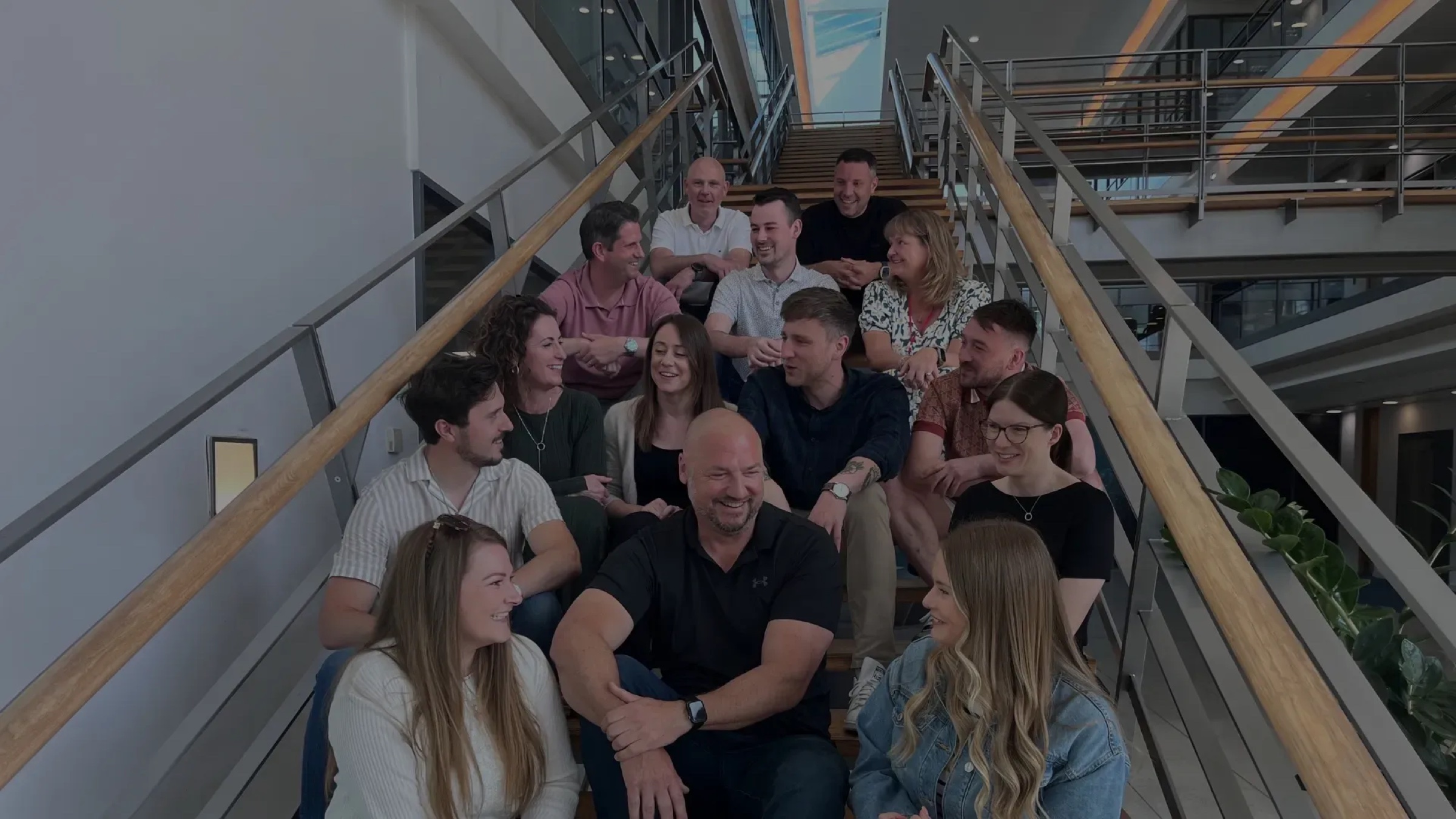 The ONE Group team together on the office stairs